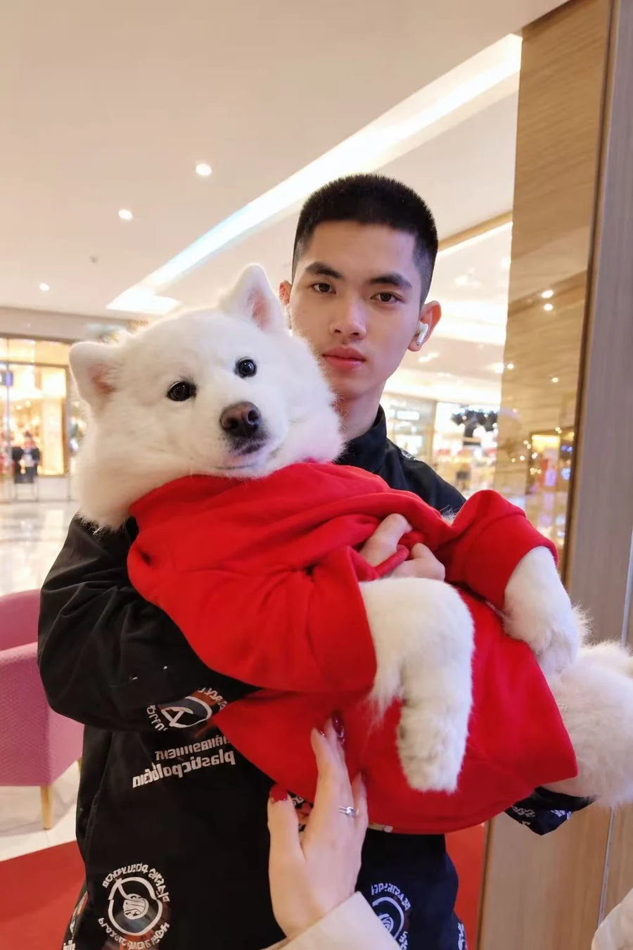Alex Xie holding his Samoyed, Duo.