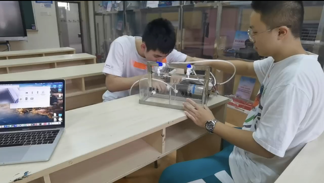 Jimmy and Alex working together on the microfiber-filter prototype in their school workshop.