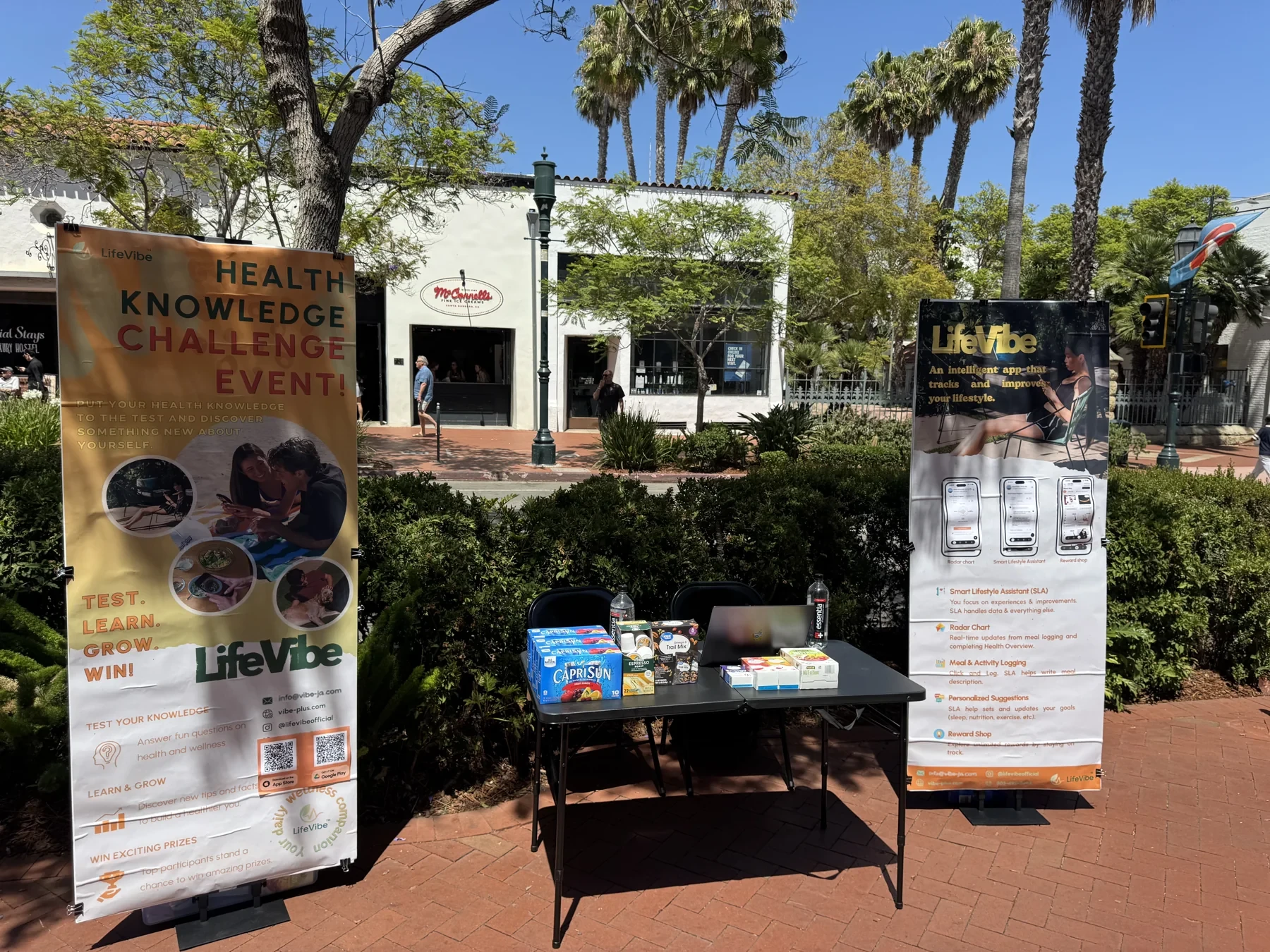 LifeVibe’s first public booth on State Street in Santa Barbara, California, with two product banners and a demonstration table, May 2026.