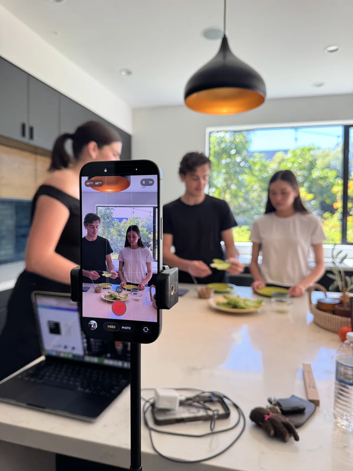 Behind the scenes of a LifeVibe app video shoot, with a phone filming people preparing food together.